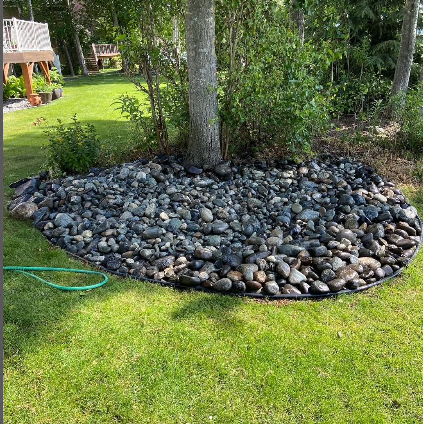 Professional landscape design with decorative rock mulch and tree installation
